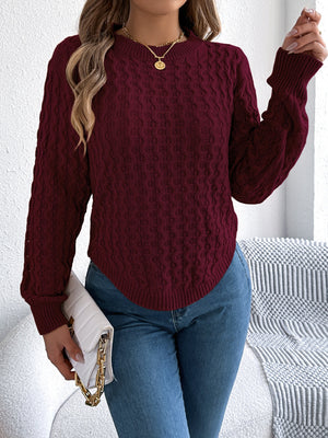 Burgundy cable knit sweater with asymmetric hem, crew neck, and long sleeves.