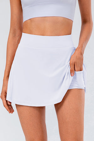 White performance skort with built-in shorts and pocket detail.