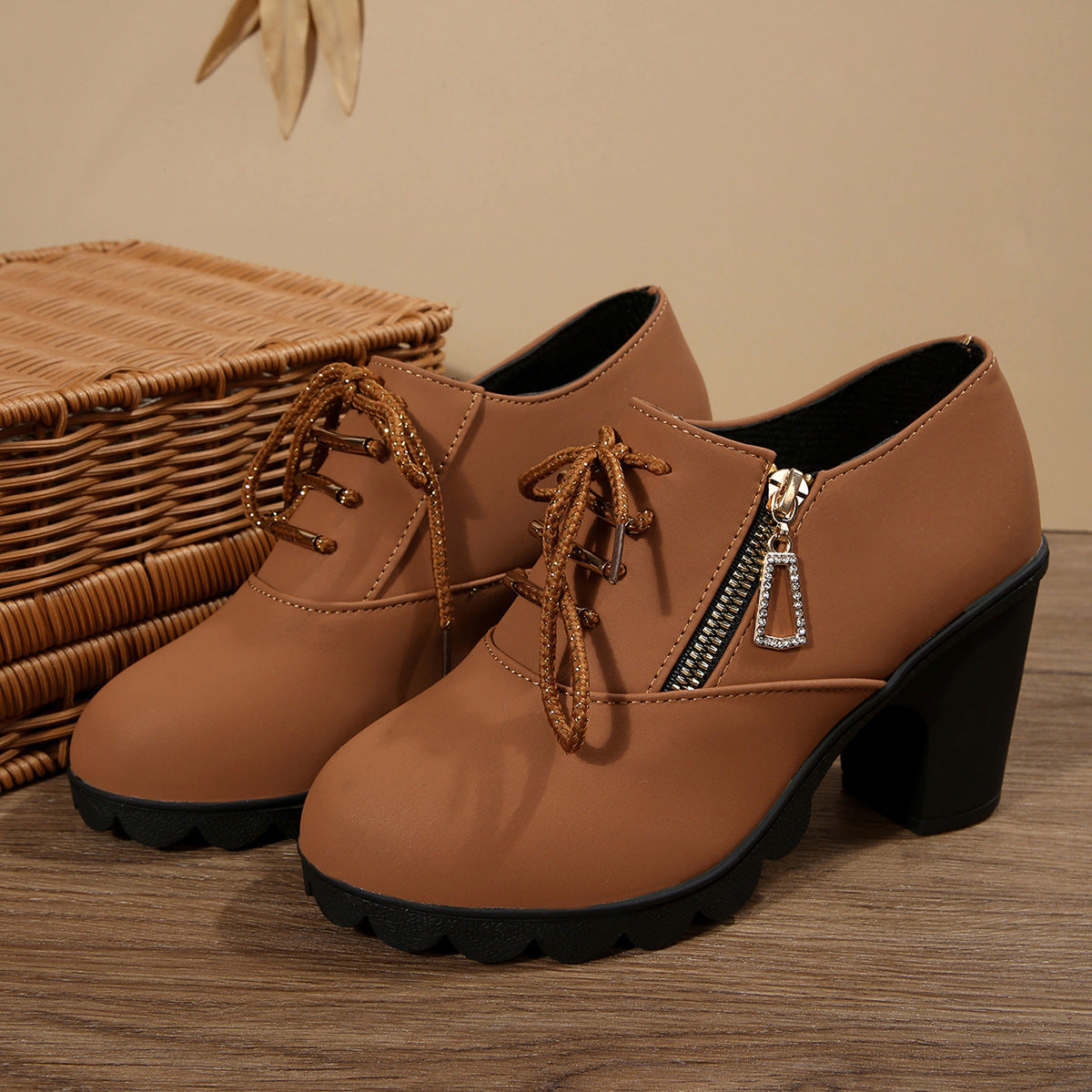 Brown lace-up block heel boots with side zipper and crystal charm.