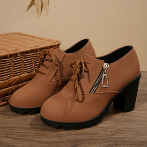 Brown lace-up block heel boots with side zipper and crystal charm.