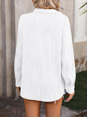 White oversized button-down shirt with textured vertical pleats and a collared neckline.