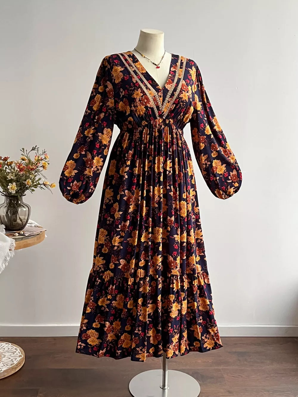 Floral V-neck maxi dress with long sleeves, tiered skirt, and lace trim.