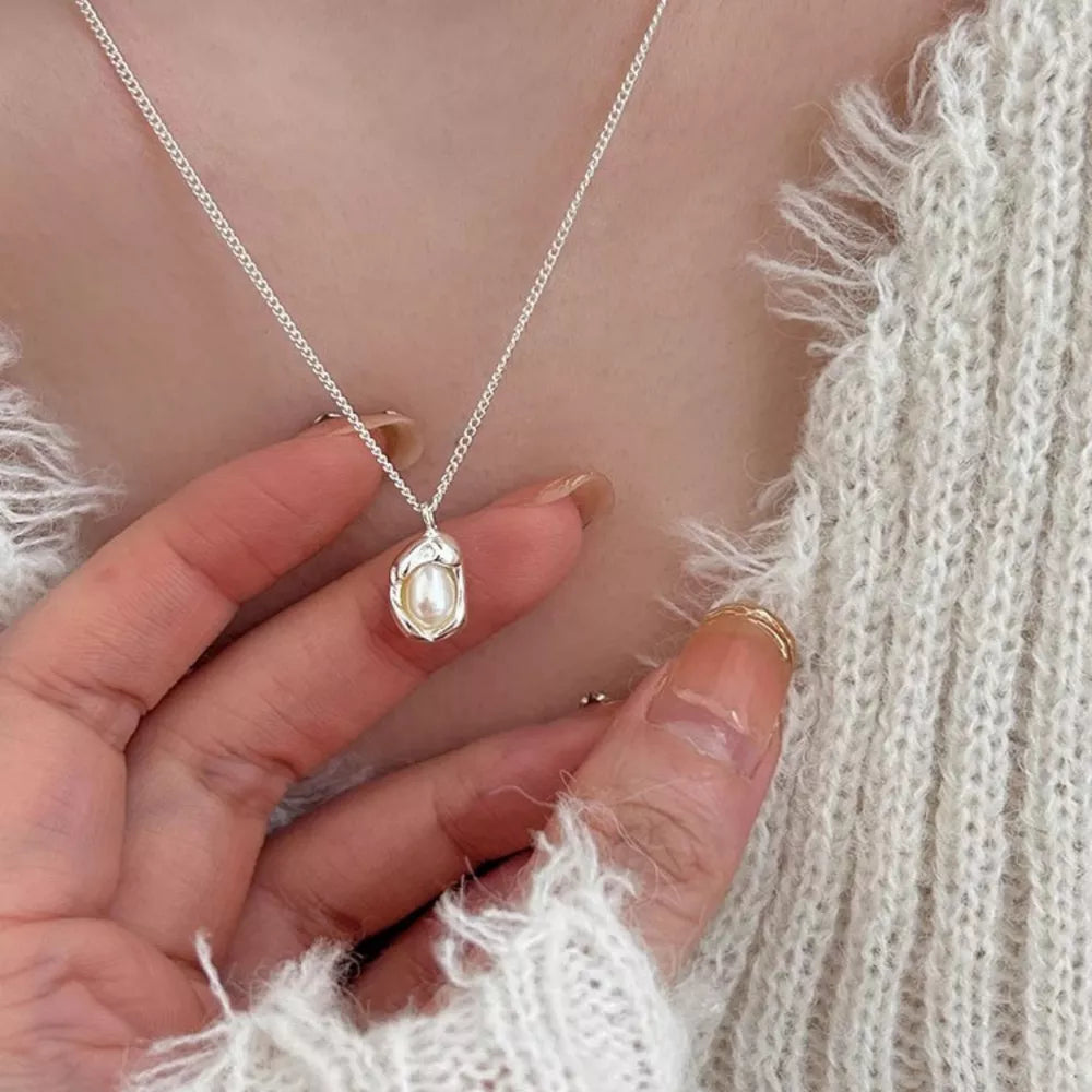 Silver necklace with lustrous freshwater pearl pendant, delicate chain.
