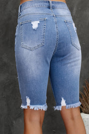 Light wash denim bermuda shorts with ripped knees and frayed hem.