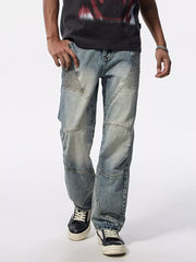 Men's light wash wide-leg moto jeans with textured knee panels and a relaxed fit.