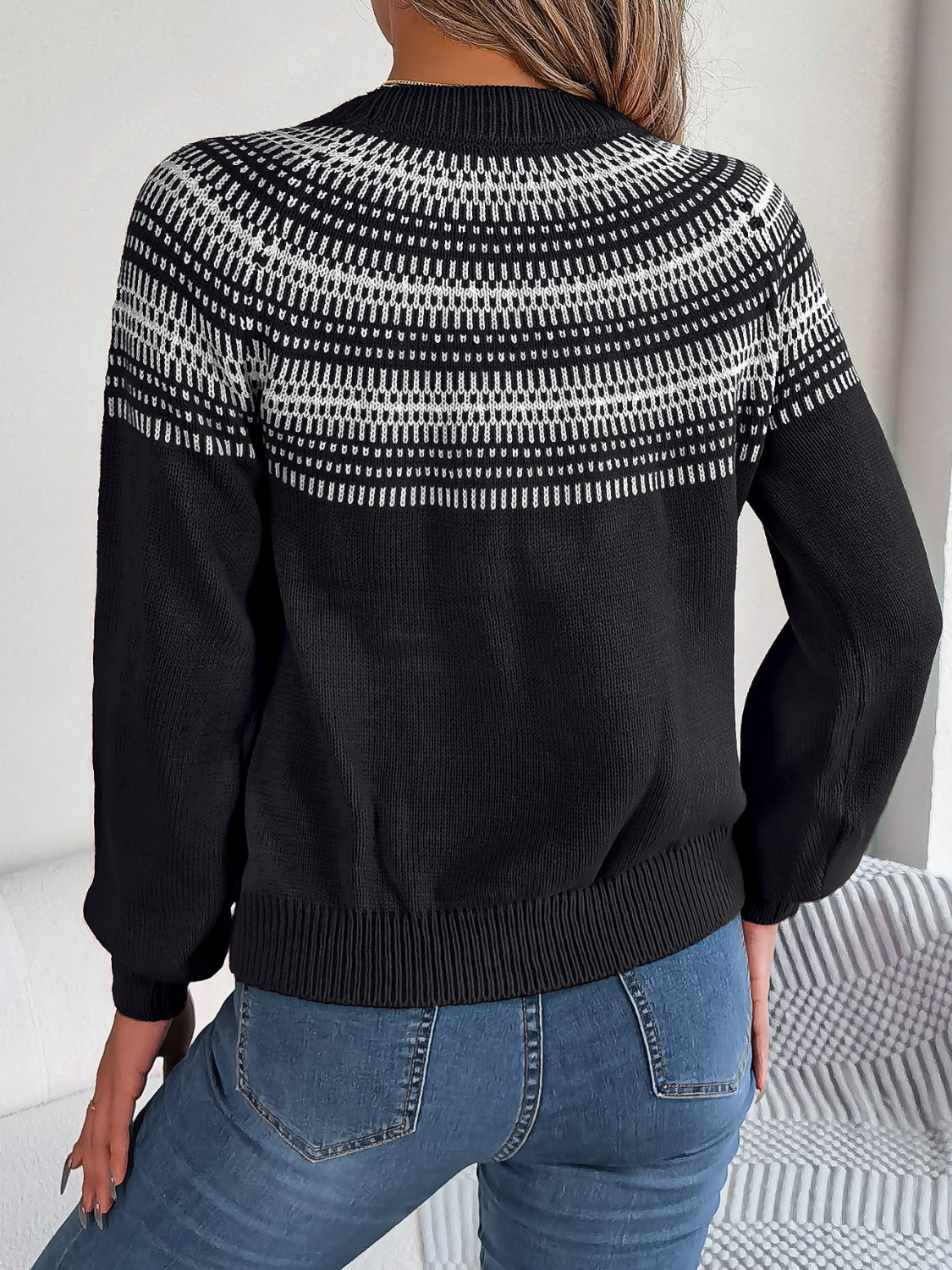 Black knit sweater with geometric yoke pattern and crew neck.
