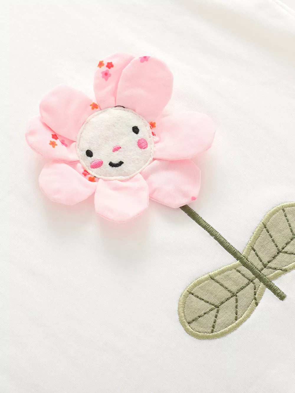 Toddler cotton set with a pink floral applique featuring a smiling face and embroidered leaves.