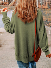 Moss green sweatshirt with balloon sleeves and side slits, styled with a crossbody bag.