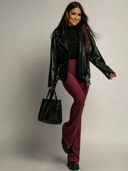 High-waisted flared trousers in red, styled with a black leather jacket and handbag.