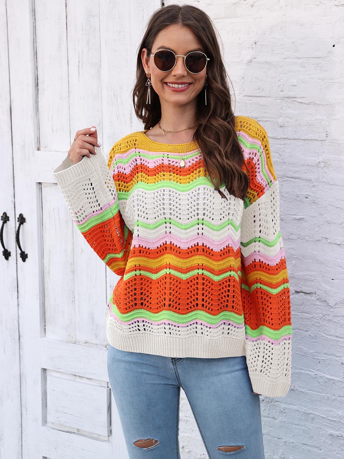 Crochet sweater with rainbow wave pattern, crew neck, long sleeves, and open knit details.