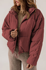 Cropped puffer jacket in brick red with a hooded collar and zipper closure.