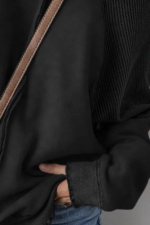 Black waffle knit raglan sweatshirt with textured sleeves and cuffed hem.