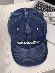 Dark blue denim baseball cap with white Los Angeles embroidery and contrast stitching.