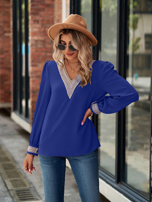 Royal blue blouson sleeve top with embroidered trim neckline and cuffs.
