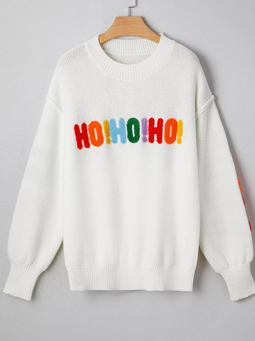 White chenille holiday sweater with rainbow HO HO HO graphic and crew neck.