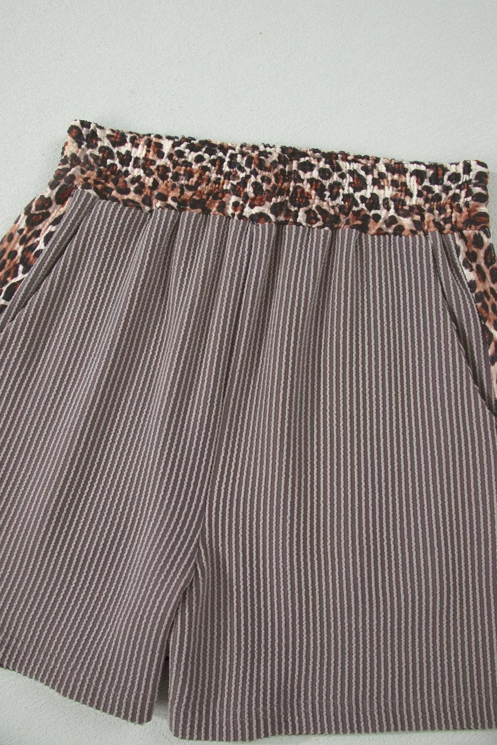Brown ribbed knit shorts with elastic leopard print waistband and side trim.