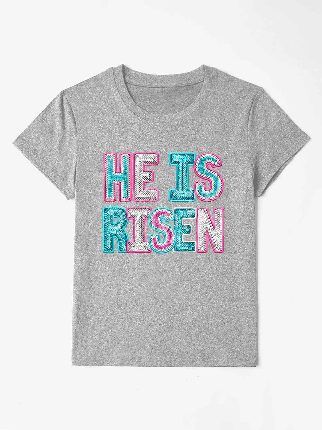 Gray crewneck t-shirt with sequin "He Is Risen" graphic in aqua and pink.