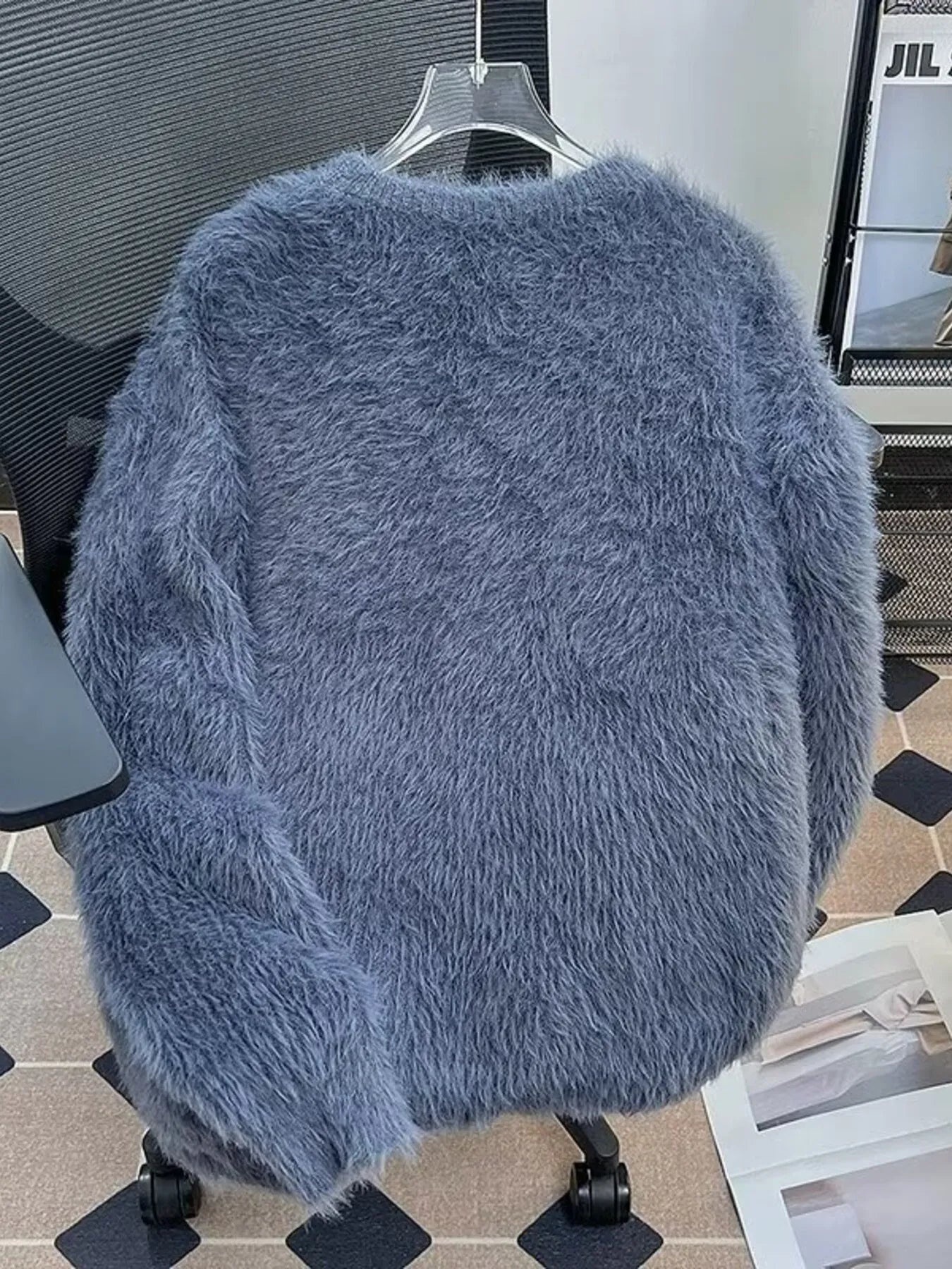Blue fluffy knit pullover sweater with a soft, fuzzy texture.