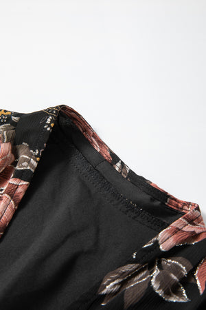 Black floral print blouse with surplice neckline and blouson sleeves.