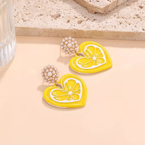 Charming heart-shaped dangle earrings with lemon slice design and pearl accents.