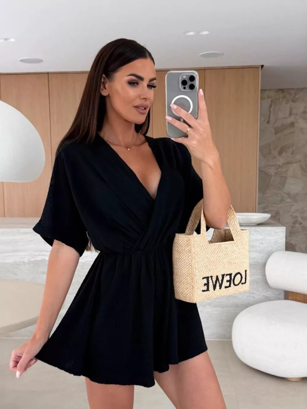 Black V-neck romper with twist detail and dolman sleeves