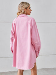 Pink denim shirt dress with raw hem and button cuffs, shown from the back.