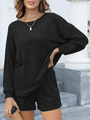Black ribbed knit loungewear set with long sleeves and shorts, featuring side pockets.