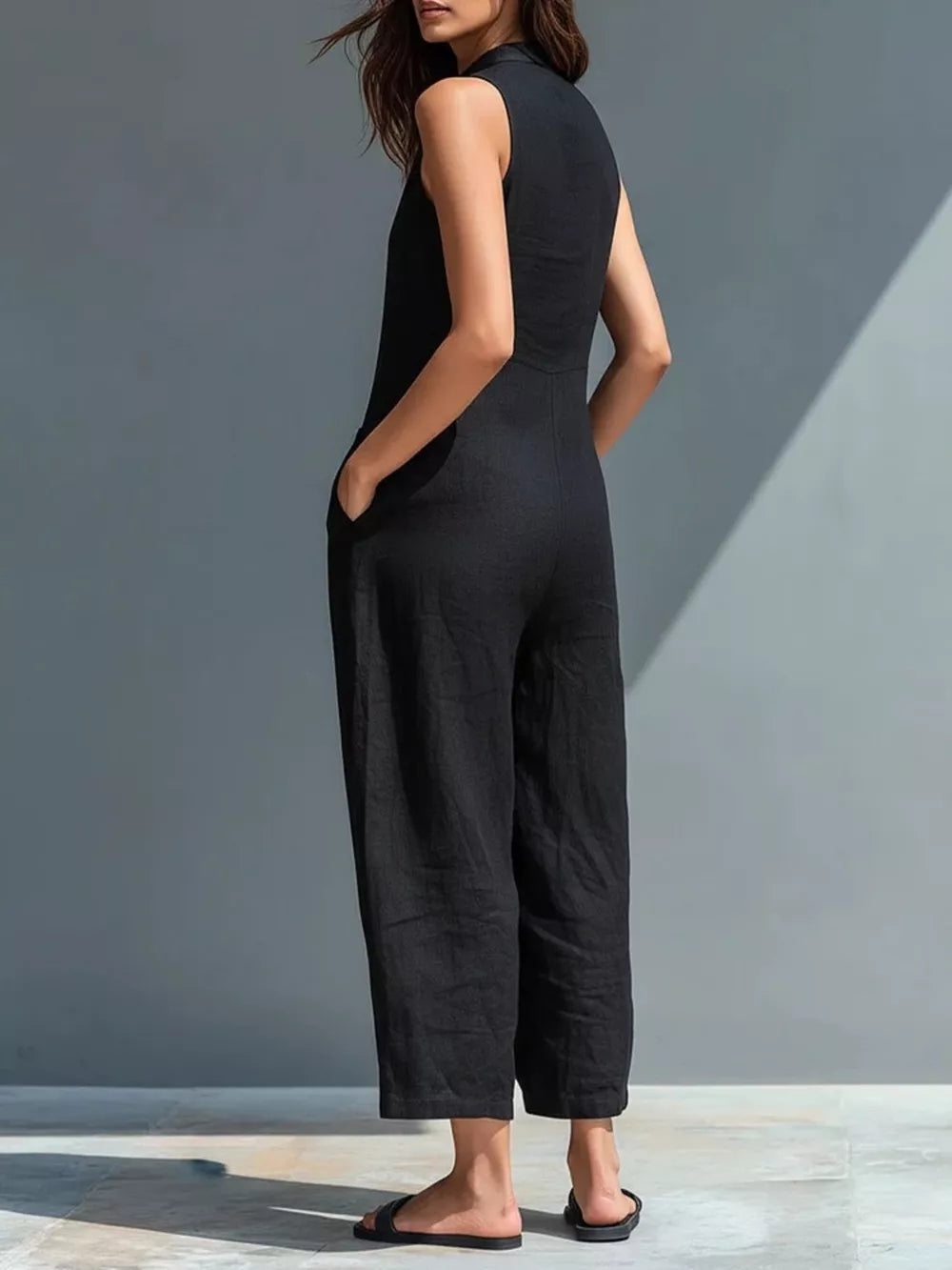 Black sleeveless button-down romper with pockets and wide legs.