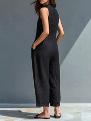 Black sleeveless button-down romper with pockets and wide legs.