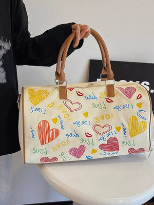 Vibrant canvas duffel bag with colorful heart and lips print, brown trim, and adjustable strap.