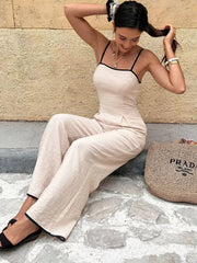 Chic Contrast Trim Wide-leg Romper in beige with black trim, spaghetti straps, and wide legs.