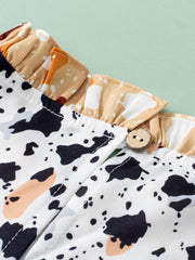 White blouse with terrazzo print, ruffle yoke detail, and wooden button closure.