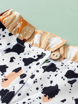White blouse with terrazzo print, ruffle yoke detail, and wooden button closure.