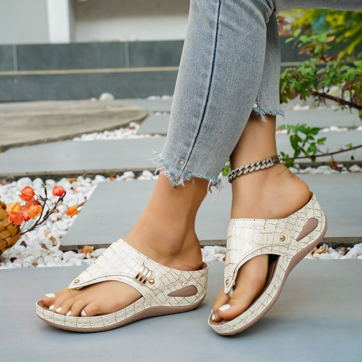 Beige crocodile-embossed wedge thong sandals with gold buckle detail.