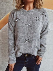 Gray knit crewneck sweater with scattered satin bows, crew neck, long sleeves.