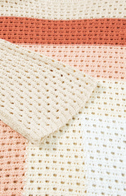 Ombre crochet sweater in beige with open knit panels and a striped pattern.