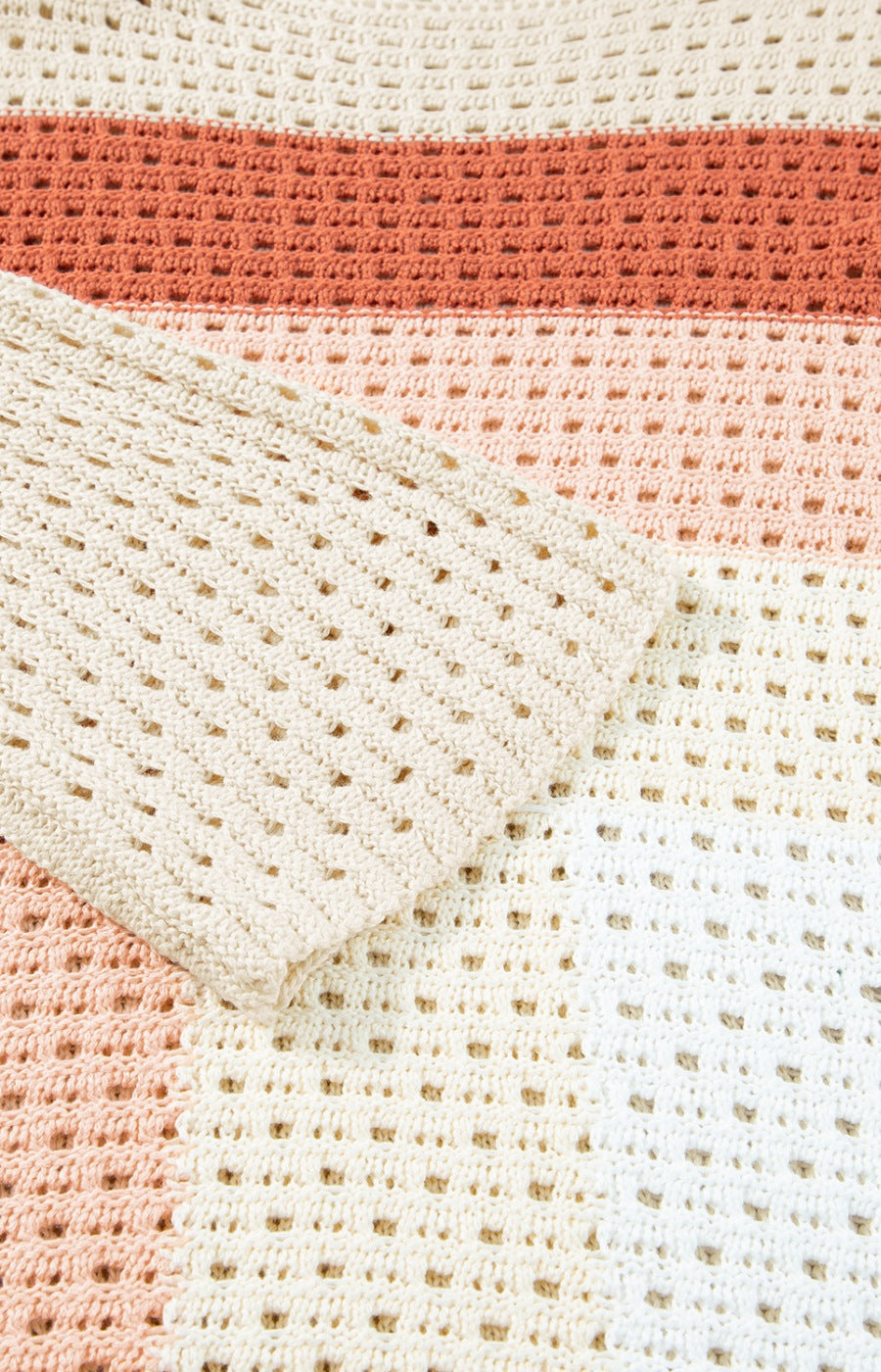 Ombre crochet sweater in beige with open knit panels and a striped pattern.