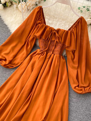 Orange ruffled square neck maternity dress with smocked bodice and balloon sleeves.