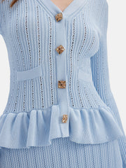Light blue knit cardigan with ruffled hem, gold buttons, and pockets.