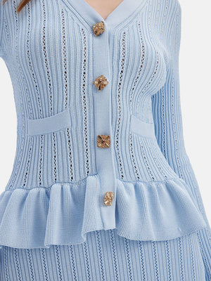Light blue knit cardigan with ruffled hem, gold buttons, and pockets.