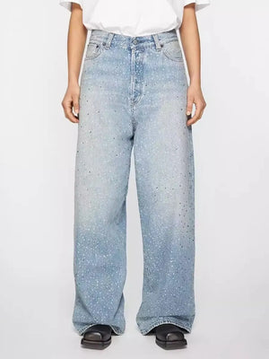 Embellished wide-leg denim trousers in medium wash with scattered rhinestones.