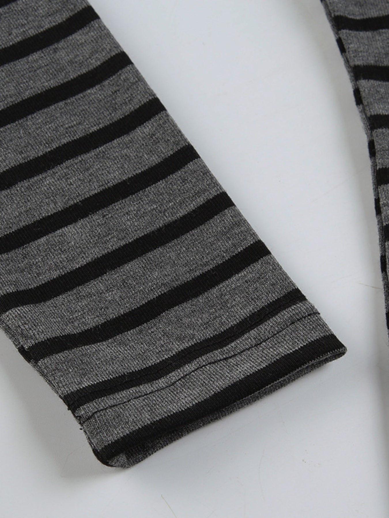 Grey and black striped t-shirt with a boat neck and long sleeves.