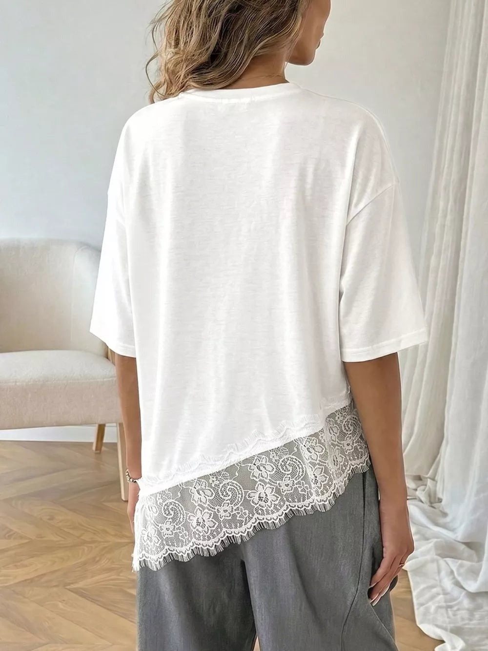 White lace-embellished asymmetrical hem tee with half sleeves.