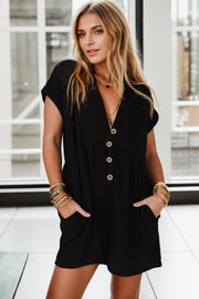 Black button-down empire waist romper with short sleeves and V-neckline.