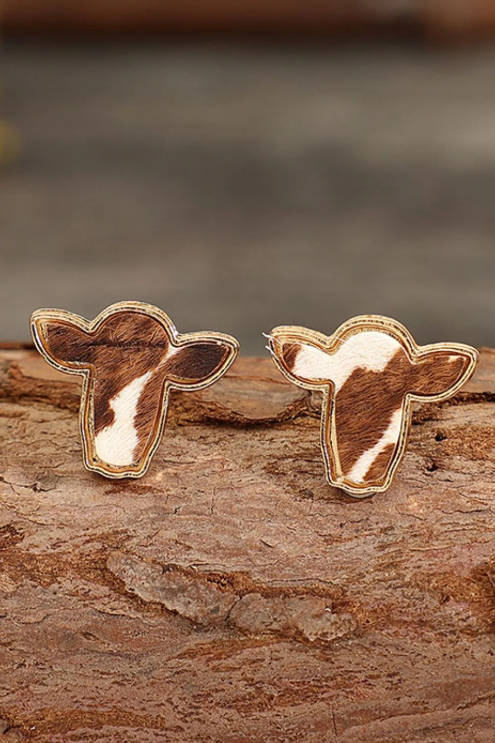Cowhide silhouette stud earrings in copper with gold trim and natural cowhide pattern.