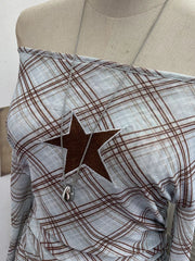 Asymmetrical ruffle hem t-shirt in blue plaid with a brown star detail and off-the-shoulder neckline.