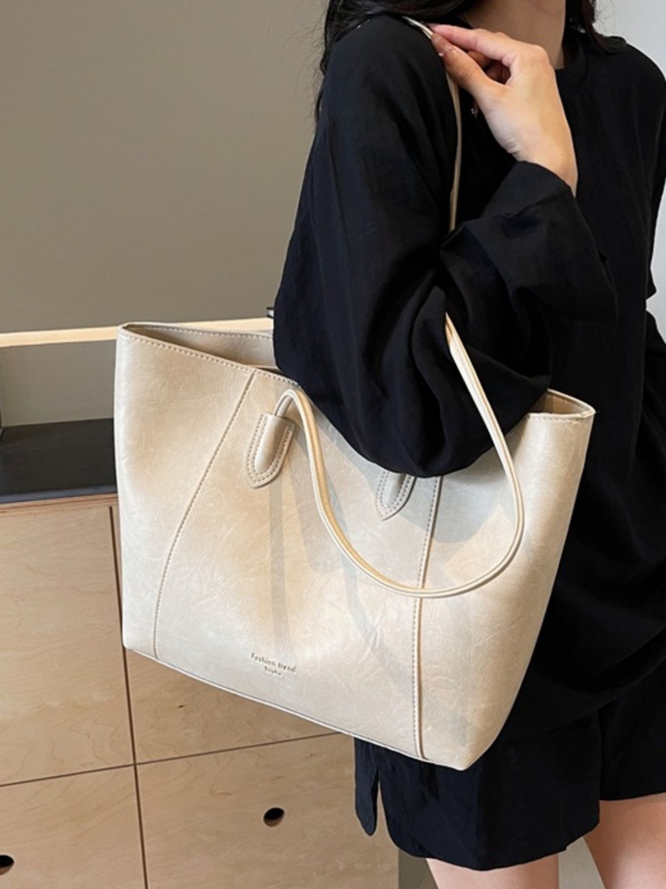 Off-white crinkled pu leather tote bag with top handles and subtle stitching detail.