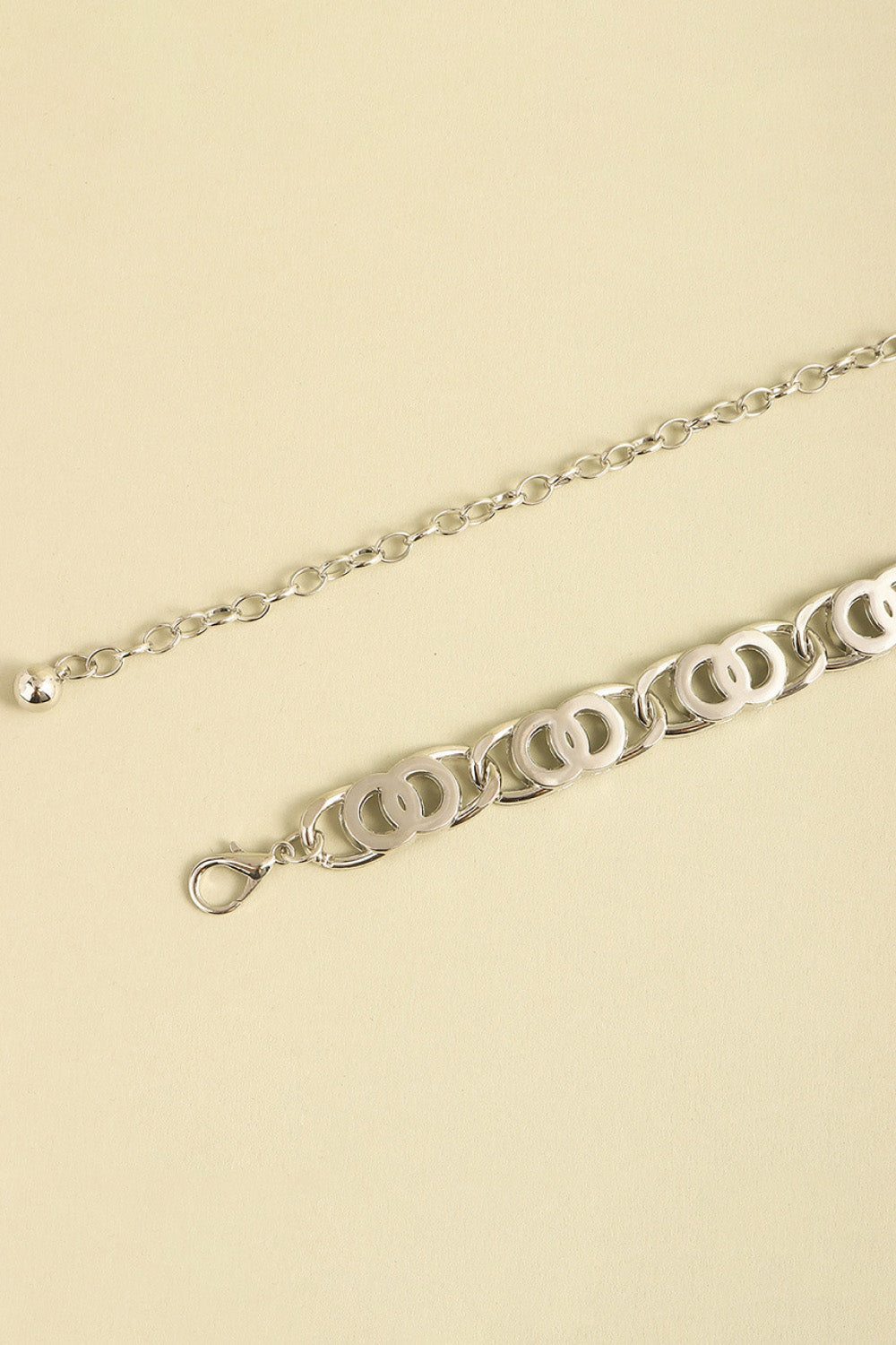 Silver chain belt with interlocking circle links and a lobster clasp closure.