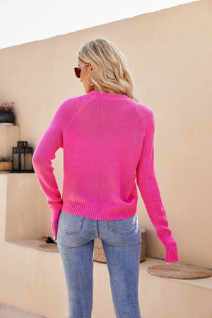 Pink acrylic knit button-up cardigan with raglan sleeves and ribbed trim.