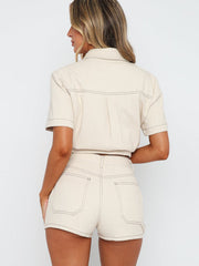 Cream utility set with contrast stitching, featuring a buttoned short sleeve shirt and high-waisted shorts.